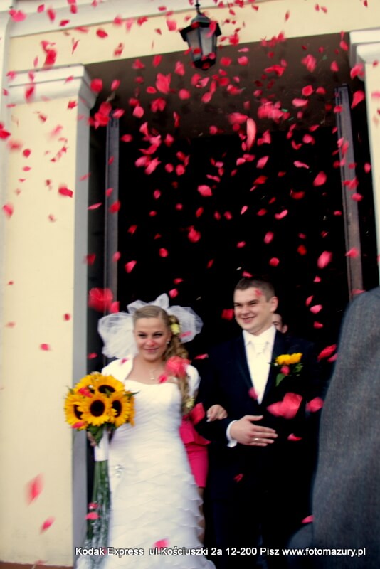 flowers thrown on bride and Groom as they exit their church wedding in poland
